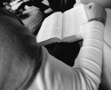 A young person reading a Bible.