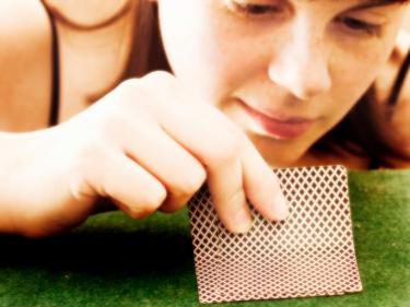 Girl peeking at cards - The Only Sure Thing