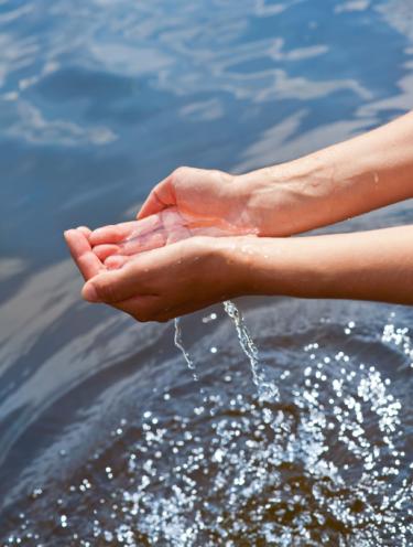 Hands holding water over more water - Understanding God