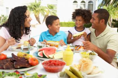 Parents and children around table with BBQ food - What Happened to the Family Me