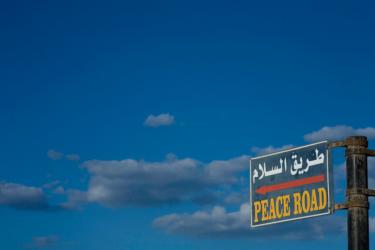 Sky and road sign "peace road" in english - When Will Peace Come to