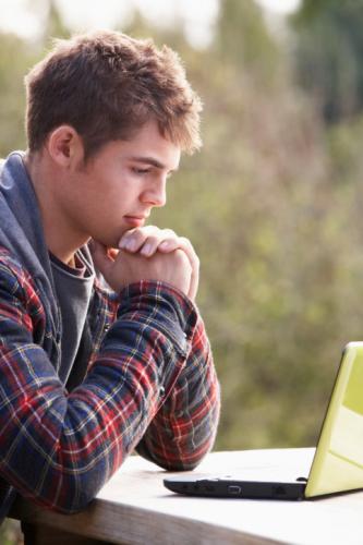 Young man with laptop computer - Who Delivers Us From Sin?