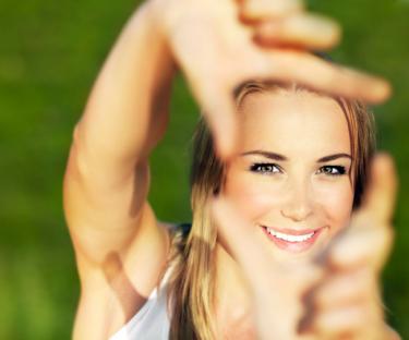 Girl smiling with fingers making a frame - Who Is the Center of Our Worship?