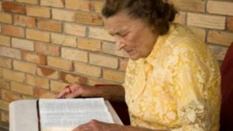 Understanding God's Word... What Is the Gospel? Older woman reading bible on a table - Understanding God's Word... What Is the G