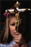 Little girl holding a large cross