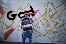 A boy spray painting God's name as graffitti.