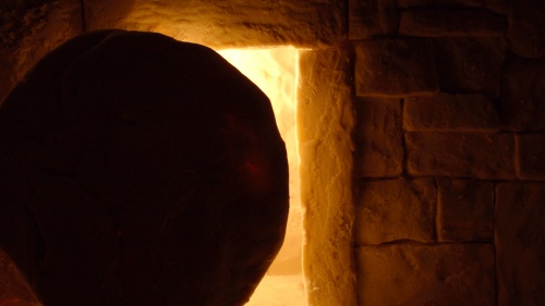 A round stone in front of a tomb entrance.