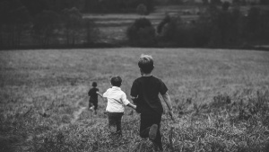 Three boys running in a field