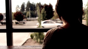 A woman looking out a window.