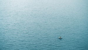 A tiny boat in a big sea of water.