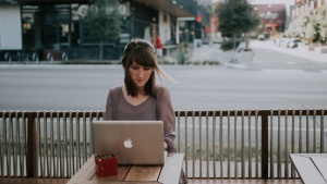 A young woman looking a laptop screen.