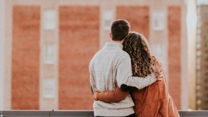 A couple looking out over a wall.