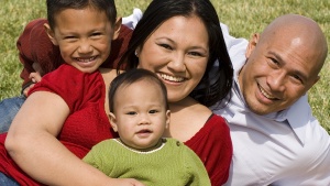 A family lying down on a blanket.