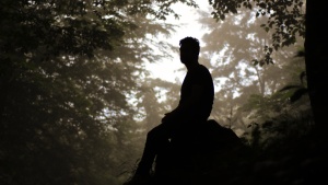 A man sitting on a rock.