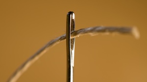 A thread going through the eye of a needle.