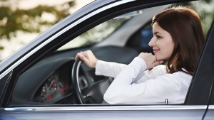 A young woman driving her new car.