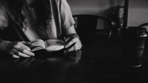 A woman reading a Bible in a coffee shop.