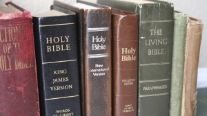 Various Bibles on a shelf.