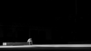 A person sitting on a concrete bench.