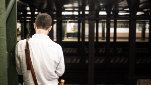 A man waiting at a subway station.