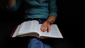 A person with a Bible on their lap.