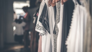 A woman going through a closet of clothes.