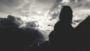 Woman with sun rays in background.