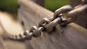 Heavy chain across a piece of wood.