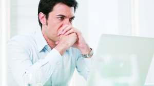 A man looking at his laptop screen.