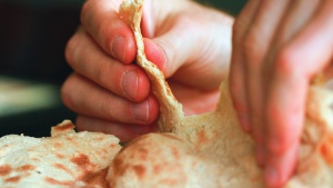 A person tearing unleavened bread.