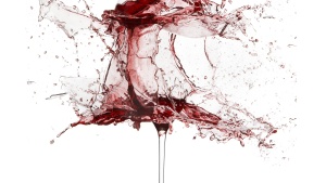 A wine glass exploding with wine.