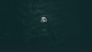 The moon through dark clouds.
