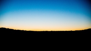 A sunset over a dark hill.