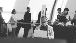 A man sitting in an airport terminal looking at this laptop screen.