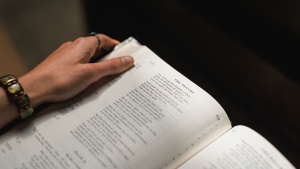 A woman holding a Bible opened to the Psalms. 