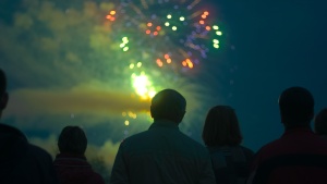 People watching the night sky filled with fireworks.
