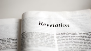 A Bible opened to first page of Revelation.