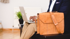 A man typing on his laptop while sitting on a couch.