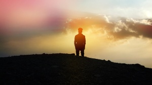 A person standing of top of a hill.