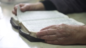 A older person reading a Bible.