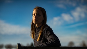 A young woman sitting on a bench.