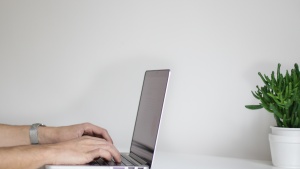 A man typing on a laptop computer.