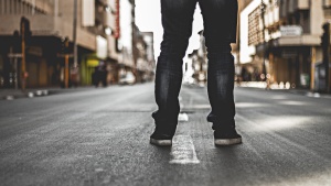 A person standing in the middle of a road.