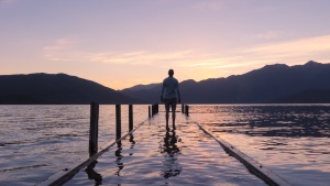 A man standing on a dock covered by water.