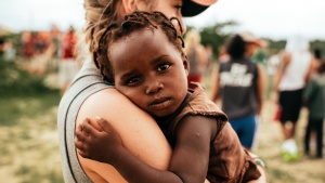 A young woman holding a small child.
