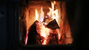 A fire burning inside a wood stove.