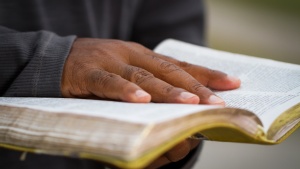 A man holding an open Bible.