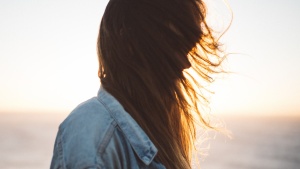 Sun rays shining through a young woman's hair.