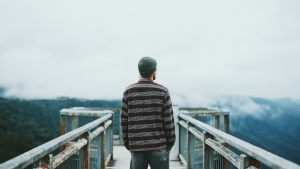 A man walking on a wooden path.