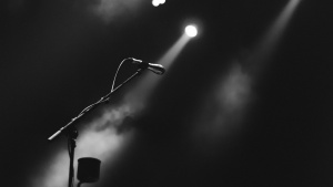 A microphone on a stage lit by a spotlight.